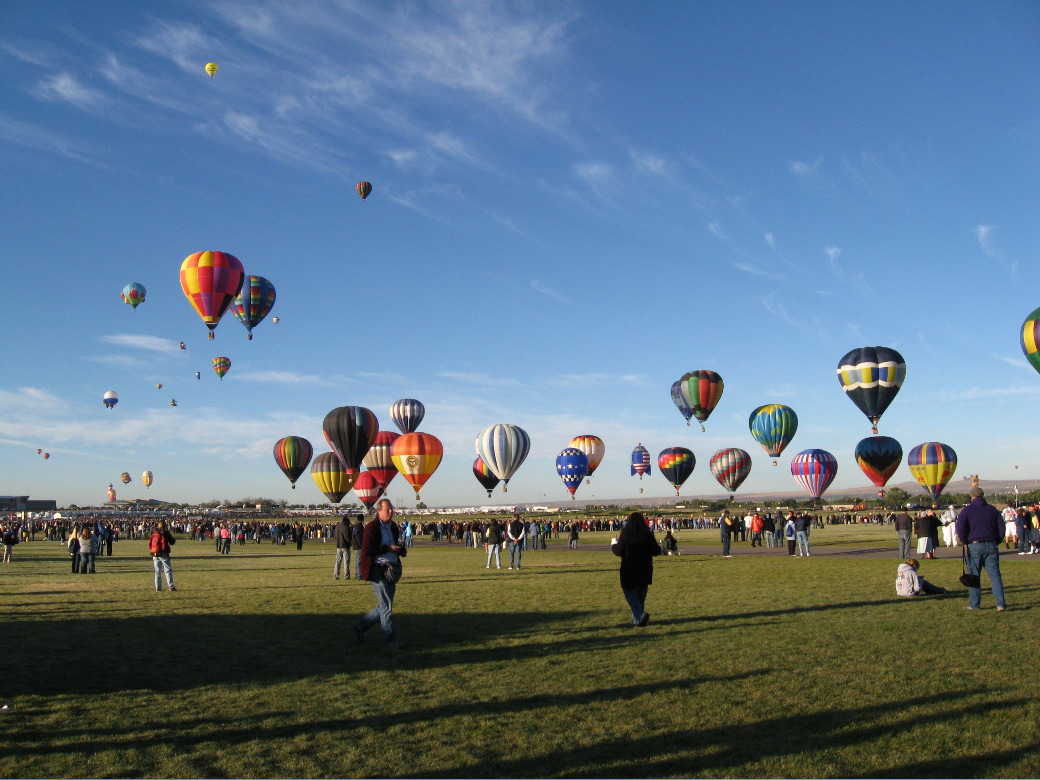 The prize is out of sight to the left.  When the balloons miss, they rise up to the wind above that goes in the exact opposite direction.  So it makes a big ring of moving ballons